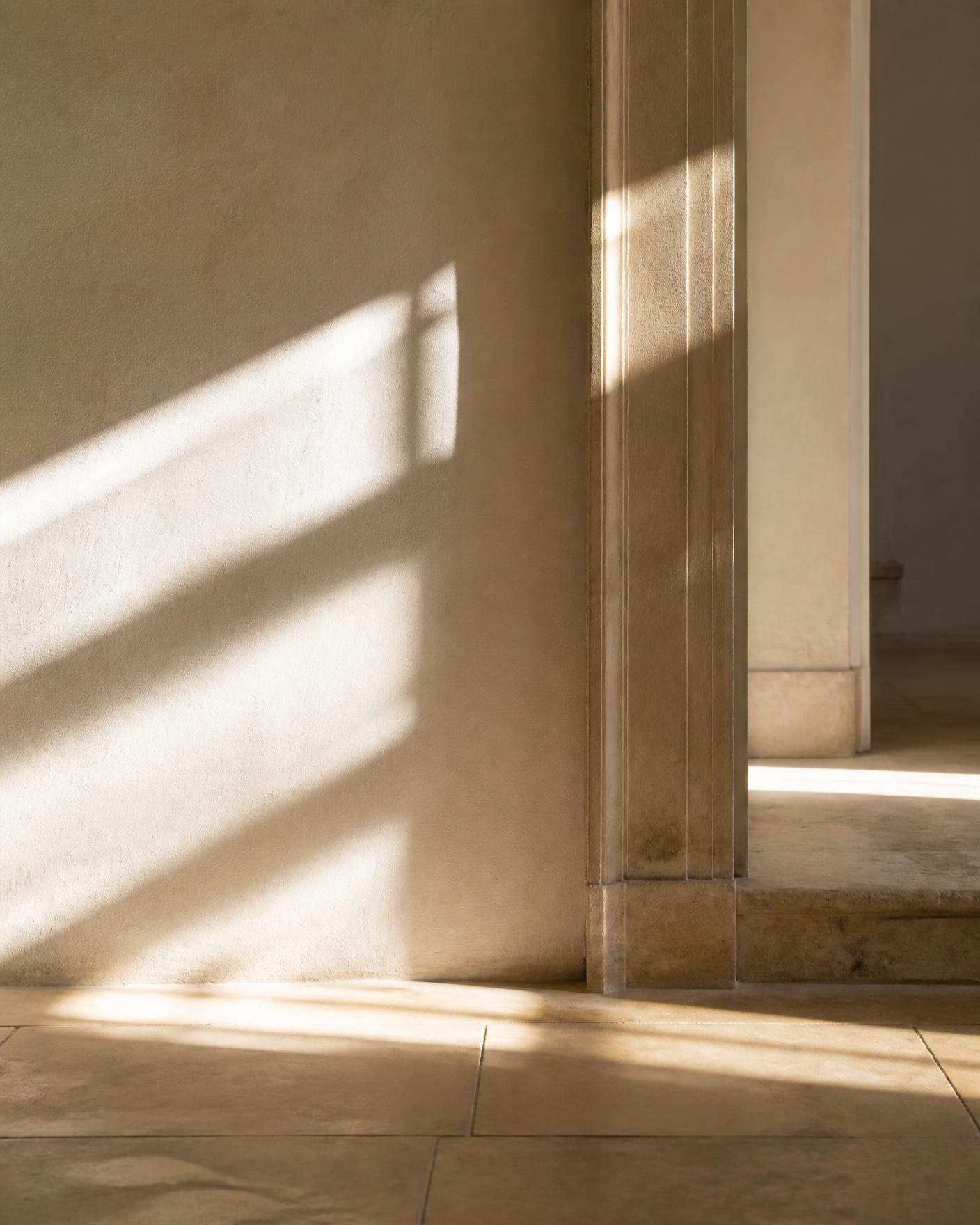Light and shadow across a stone floor in an empty interior